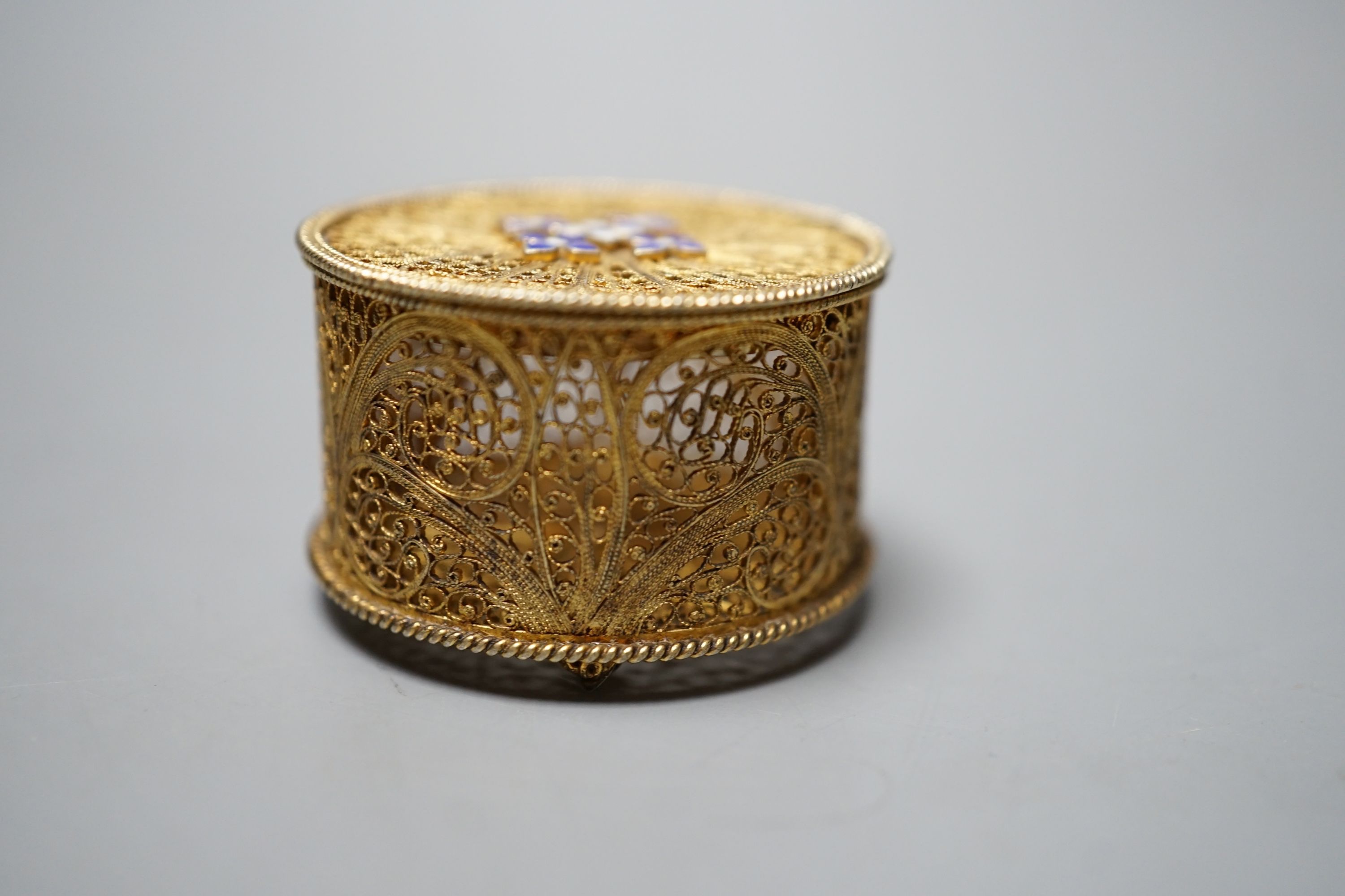 A late 19th/early 20th century Portuguese gilt white metal filigree and two colour enamel circular pill box, 35mm.